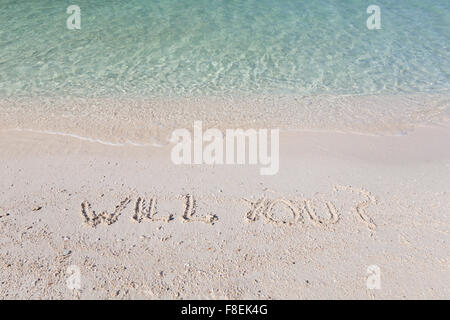 Will you? written out in wet sand on a tropical beach in Thailand Stock Photo