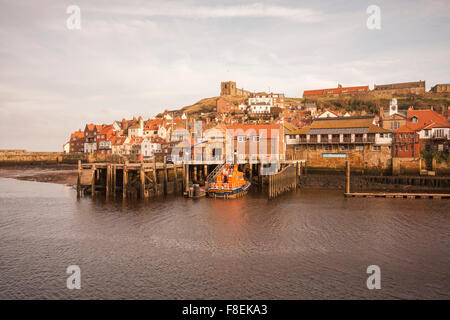 View of the East side of Whitby showing cliff side houses,St.Marys Church and the Whitby lifeboat berthed in the harbour Stock Photo