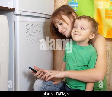 Mother teaches child to emergency phone numbers Stock Photo