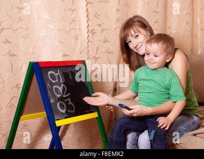 Mother teaches child to emergency phone numbers Stock Photo