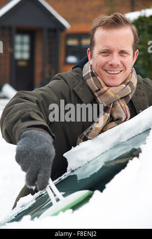 Man Scraping Snow From Car Windscreen Stock Photo