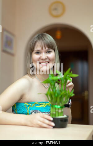 Girl with lucky bamboo plant at her home Stock Photo
