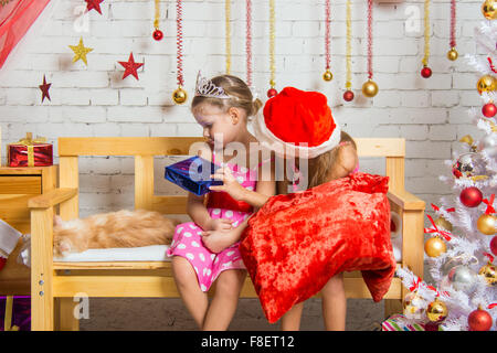Two funny sisters four girls and six years of playing and having fun in the home New Year's interior Stock Photo