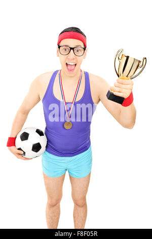 Vertical shot of a nerdy football player holding a trophy and wearing a medal isolated on white background Stock Photo