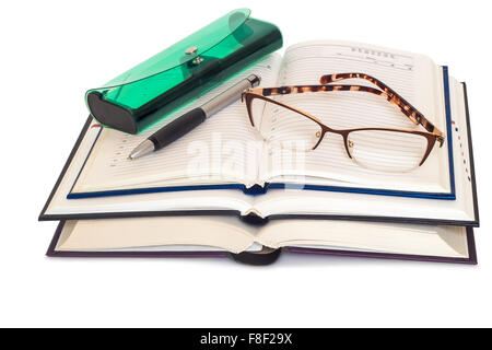 On a white background presented two books and a notebook. They are glasses, eyeglass case and pen. Stock Photo