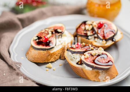 Fig toast with walnuts and balsamic vinegar on plate. Christmas appetizer Stock Photo