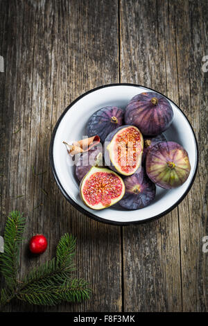Fresh figs in bowl on rustic wooden background, high angle view Stock Photo