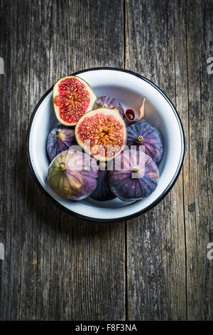 Fresh figs in bowl on rustic wooden background, high angle view Stock Photo