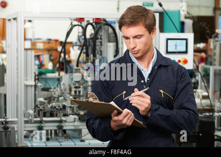 Engineer Writing On Clipboard In Factory Stock Photo