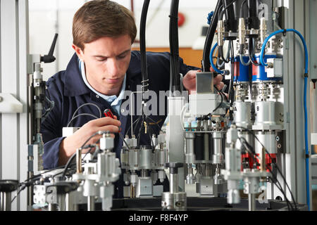 Engineer Working On Complex Equipment In Factory Stock Photo