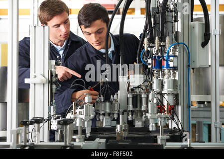 Engineer And Apprentice Working On Equipment In Factory Stock Photo