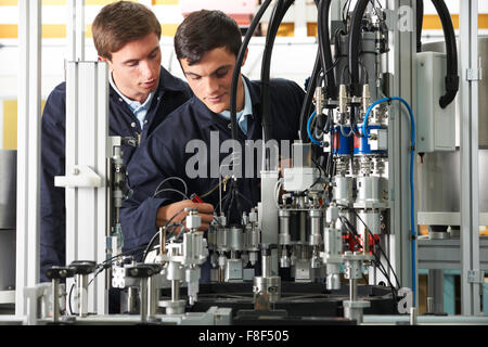 Engineer And Apprentice Working On Equipment In Factory Stock Photo