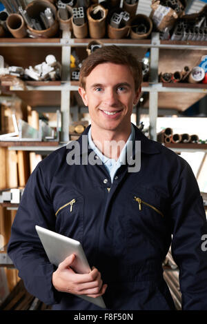Worker Checking Stock In Factory Using Digital Tablet Stock Photo