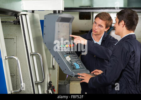 Engineer Instructing Trainee On Use Of Computerized Cutting Tool Stock Photo