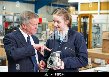Factory Manager And Engineering Apprentice Discussing Component Stock Photo