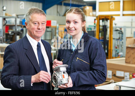 Factory Manager And Engineering Apprentice Discussing Component Stock Photo