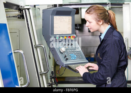 Female Engineer Operating Computer Controlled Cutting Machine Stock Photo