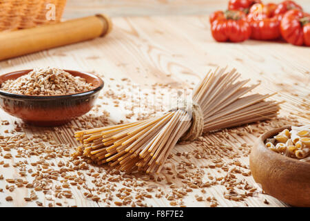 whole wheat pasta noodles surrounded by wheat Stock Photo