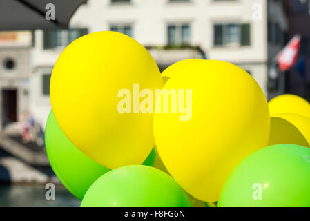 Bright yellow and green balloons on a city street event in summer Stock Photo