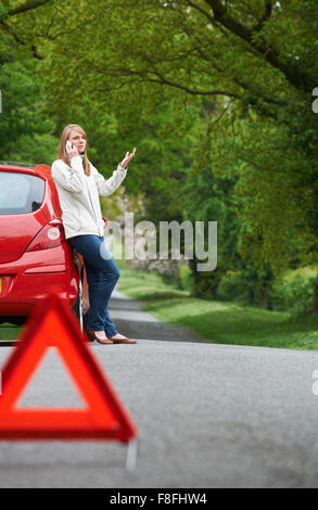 Female Motorist Broken Down On Side Of Road Stock Photo