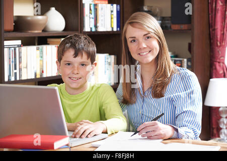 Tutor Helping Boy Studying At Home Stock Photo