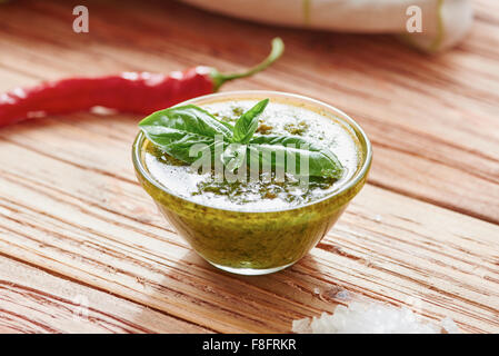 Pesto sauce on wooden table surrounded by ingredients Stock Photo