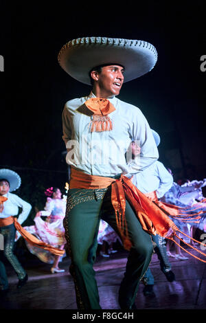 A male dancer preforming Jarabe Tapatío, a traditional Mexican folk dance, on stage in Mérida, Mexico. Stock Photo