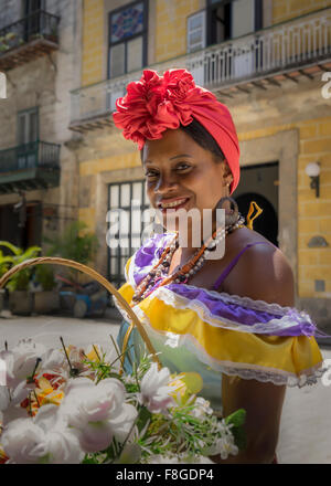 Hispanic woman carrying basket of flowers Stock Photo