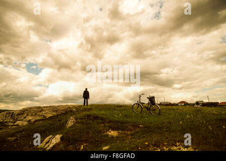 Caucasian man with bicycle in field Stock Photo