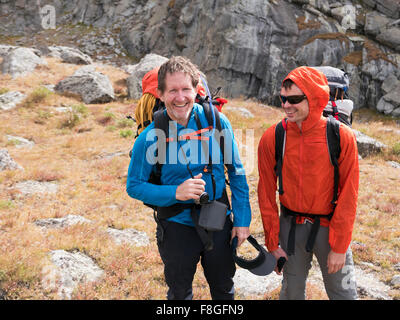 Caucasian hikers smiling on hillside Stock Photo