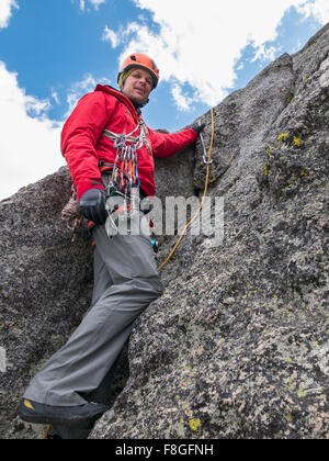 Caucasian climber using rope on rock Stock Photo