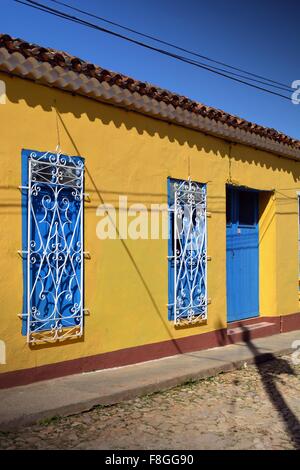 typical colorful colonial one story residence on a sunny cobbled street inTrinidad Sancti Spiritus Province Cuba Stock Photo