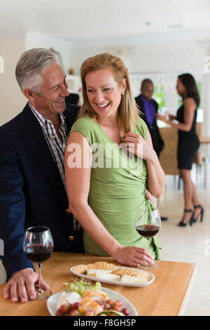 Caucasian couple drinking wine at party Stock Photo