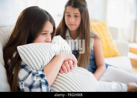 Caucasian girl comforting twin sister Stock Photo