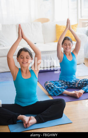 Caucasian twin sisters practicing yoga Stock Photo