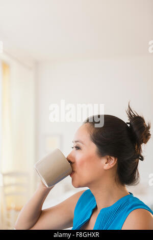 Chinese woman drinking cup of coffee Stock Photo