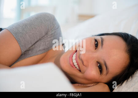 Chinese woman laying on bed Stock Photo