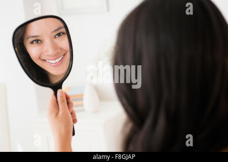 Chinese woman admiring herself in mirror Stock Photo