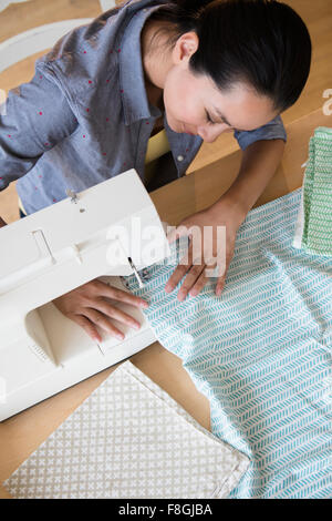 Chinese woman using sewing machine Stock Photo