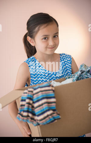 Girl holding box of clothing for donation Stock Photo