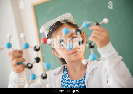 Girl examining molecular model in science class