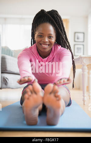 Black woman practicing yoga in living room Stock Photo