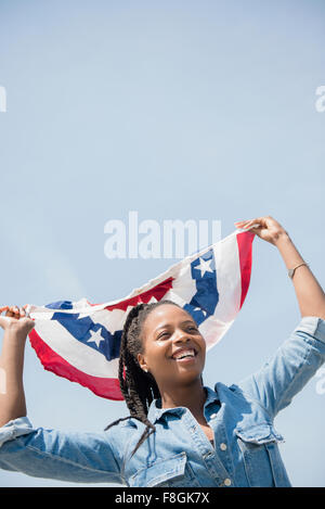 Black woman carrying American flag banner Stock Photo