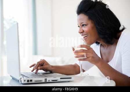Afro american woman drinking wine in kitchen at her romantic date Stock ...