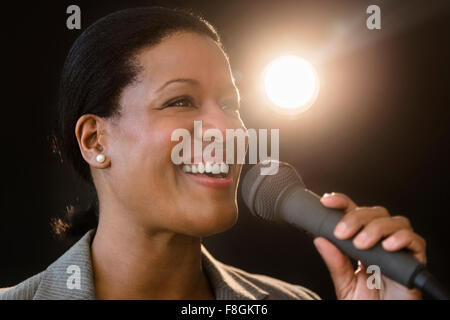 Black businesswoman talking into microphone Stock Photo
