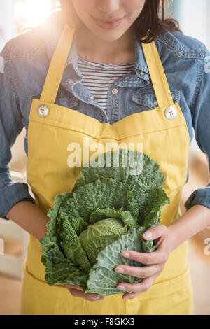 Hispanic woman holding head of lettuce Stock Photo
