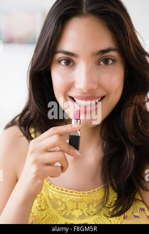 Hispanic woman applying lipstick Stock Photo