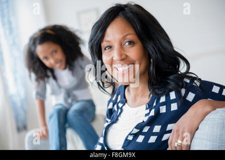 Mother and daughter smiling on sofa Stock Photo