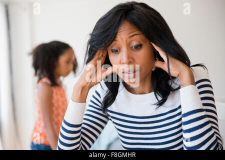 Frustrated mother rubbing her temples Stock Photo