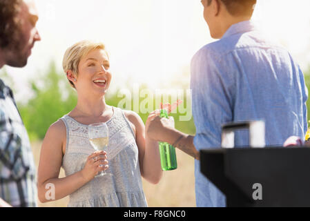 Friends talking at party outdoors Stock Photo